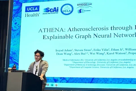 Irsyad Adam standing at a podium presenting his ATHENA work.