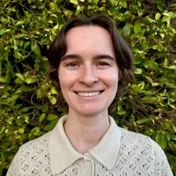 Caitlin Ree with bushes in the background.